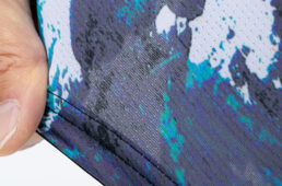 前身頃にはピンホールのような小さな穴が数ミリ間隔でびっしりと並ぶピンメッシュ素材を採用。高い通気性能と伸縮性の高さを両立。着心地の良さと優れたフィット感を実現する。後ろ身頃には適度に伸縮性がありながらポケットにものを入れても伸びにくい素材を使っている