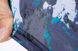 前身頃にはピンホールのような小さな穴が数ミリ間隔でびっしりと並ぶピンメッシュ素材を採用。高い通気性能と伸縮性の高さを両立。着心地の良さと優れたフィット感を実現する。後ろ身頃には適度に伸縮性がありながらポケットにものを入れても伸びにくい素材を使っている