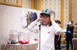 ヘルメットの被り方を指導する小川さん