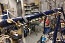 テナーサックスとアルトサックスのキーロッドを接着し、革ベルトで保持しながら取り付け