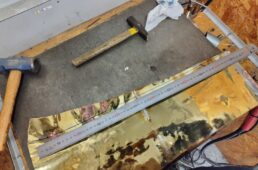 チューバを解体し、叩いて広げて切り出す準備をする