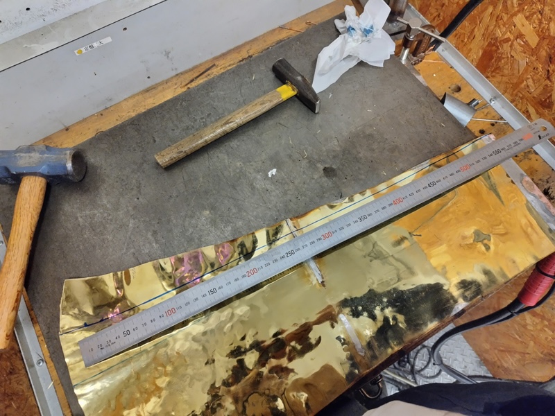 チューバを解体し、叩いて広げて切り出す準備をする