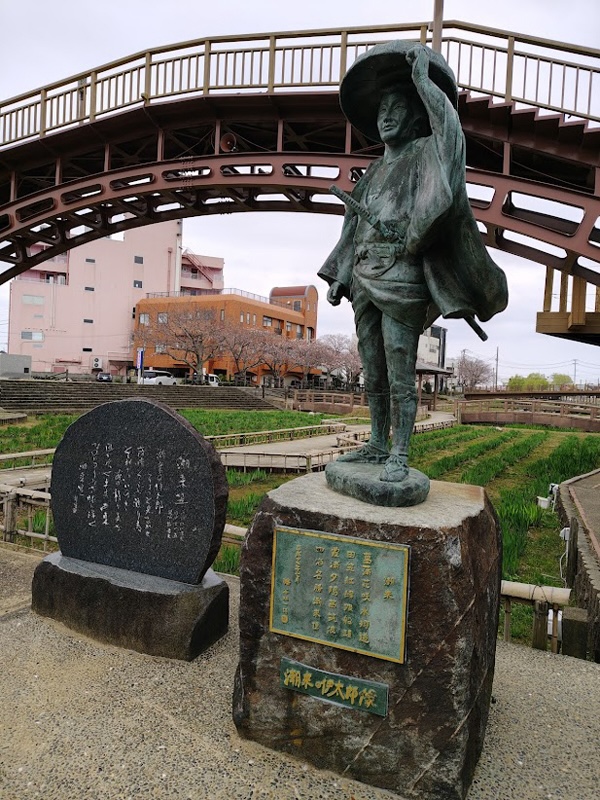 あやめ園に立つ伊太郎の像